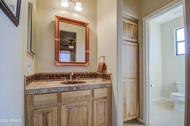 bathroom featuring tile patterned flooring, vanity, ceiling fan, and toilet