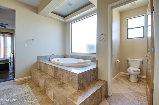 bathroom featuring ceiling fan, plenty of natural light, toilet, and tile patterned flooring