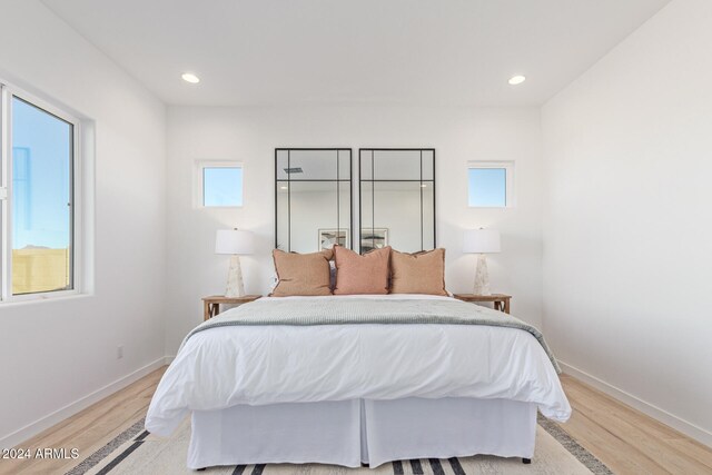 bedroom with multiple windows and light wood-type flooring