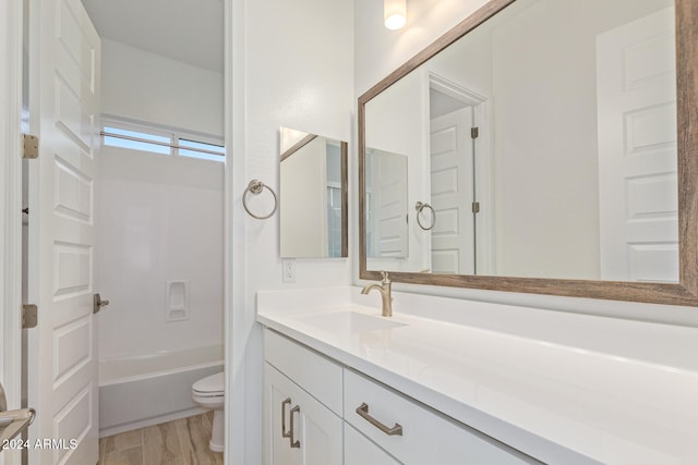 full bathroom with hardwood / wood-style flooring, vanity, toilet, and shower / bath combination