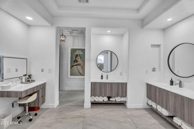 full bathroom with baseboards, visible vents, two vanities, and a tray ceiling