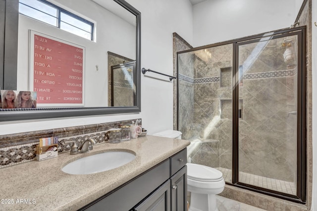 bathroom with toilet, a stall shower, and vanity