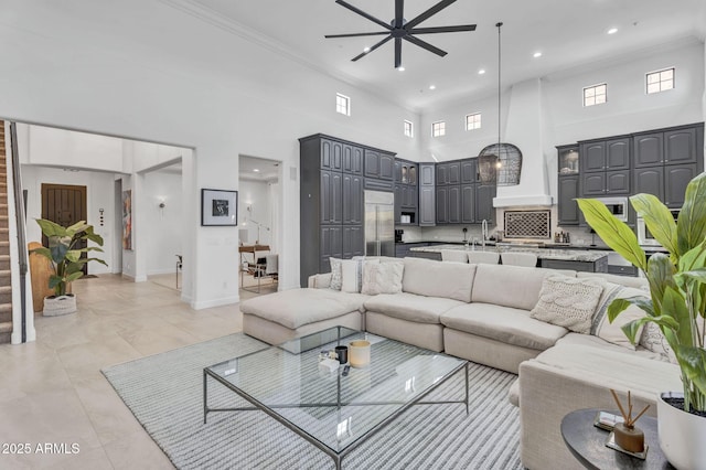 living area featuring a high ceiling, baseboards, stairs, and ornamental molding