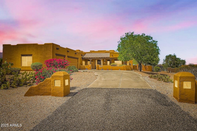 19834 W Minnezona Ave, Litchfield Park, AZ 85340 - pueblo revival-style home featuring driveway, an attached garage, and stucco siding