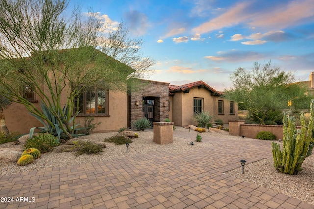 view of front of home with stucco siding and a tile roof