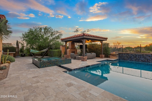 view of swimming pool featuring an outdoor fireplace, fence, a fenced in pool, a patio area, and an in ground hot tub