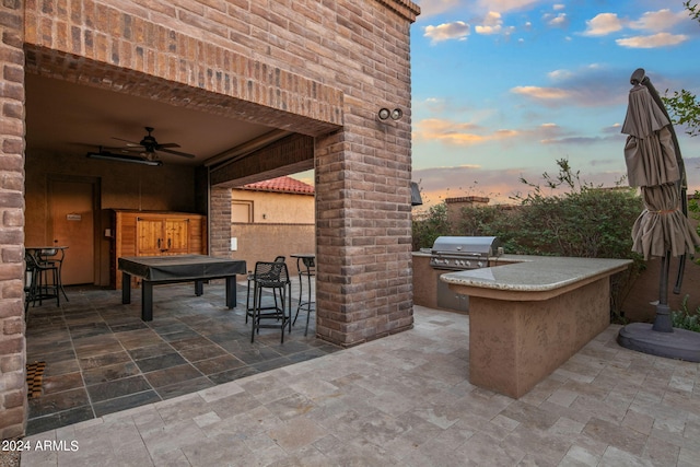 view of patio featuring an outdoor kitchen, ceiling fan, and a grill