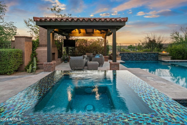 view of swimming pool featuring an outdoor fireplace, a patio, a fenced backyard, a fenced in pool, and a gazebo