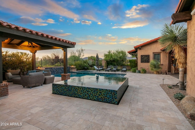 pool at dusk with a gazebo, a fenced in pool, fence, an outdoor hangout area, and a patio
