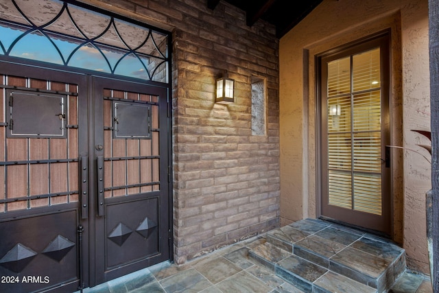 property entrance with brick siding and french doors