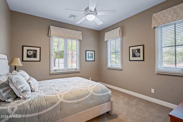 carpeted bedroom with a ceiling fan, baseboards, and visible vents