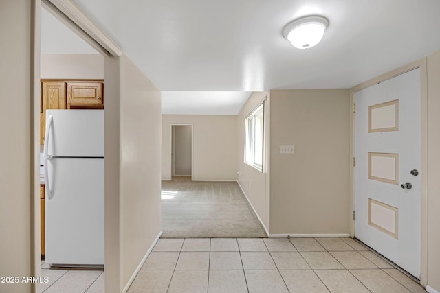 foyer with light tile patterned flooring, light carpet, and baseboards