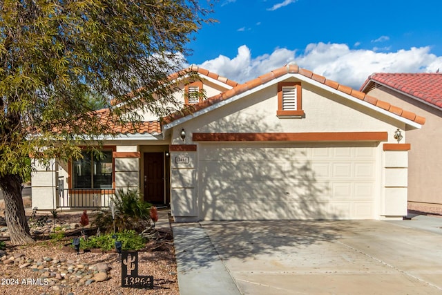 13864 W Ironwood St, Surprise, AZ 85374 - view of front of house featuring a garage, stucco siding, concrete driveway, and a tiled roof