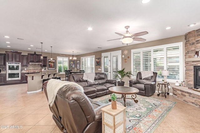 19427 W Colter St, Litchfield Park, AZ 85340 - living area featuring light tile patterned floors, recessed lighting, ceiling fan, a chandelier, and a fireplace