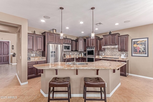 19427 W Colter St, Litchfield Park, AZ 85340 - kitchen with stainless steel appliances, under cabinet range hood, tasteful backsplash, a sink, and light tile patterned flooring