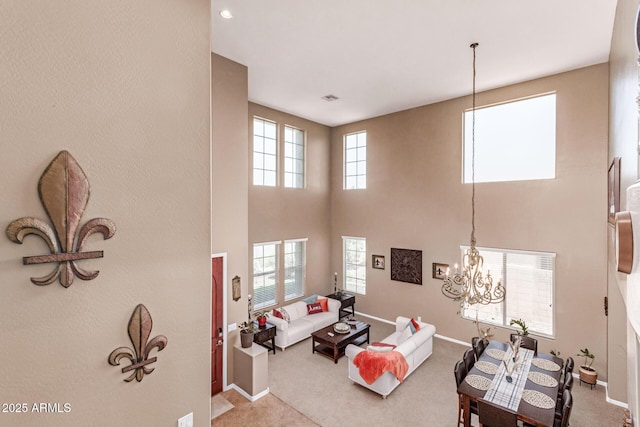 19427 W Colter St, Litchfield Park, AZ 85340 - living room featuring carpet floors, baseboards, a chandelier, and a towering ceiling