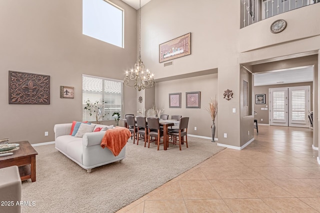 19427 W Colter St, Litchfield Park, AZ 85340 - living room with a chandelier, a towering ceiling, light colored carpet, light tile patterned floors, and baseboards