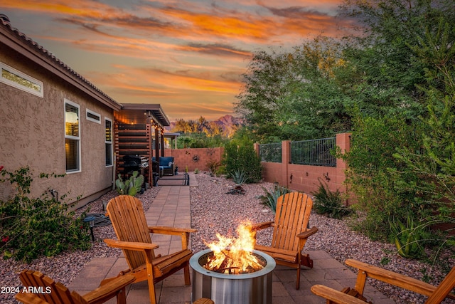 patio terrace at dusk featuring a fire pit