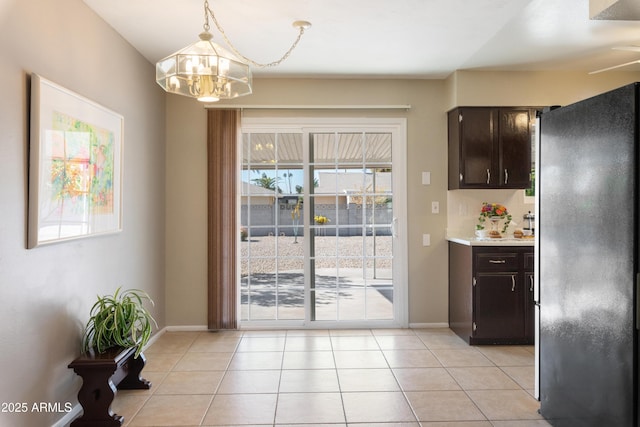 doorway to outside with an inviting chandelier and light tile patterned floors