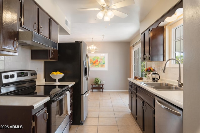 kitchen featuring pendant lighting, tasteful backsplash, sink, light tile patterned floors, and stainless steel appliances