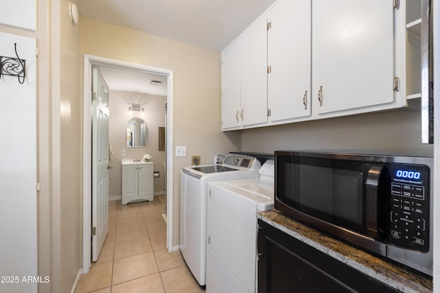 laundry area featuring cabinets, washer and dryer, and light tile patterned floors