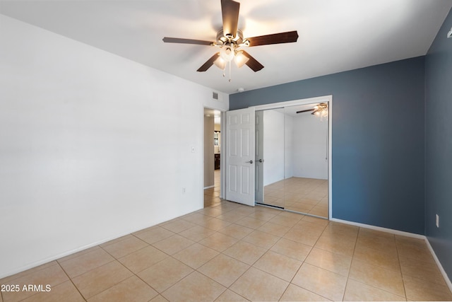 unfurnished bedroom with ceiling fan, a closet, and light tile patterned floors