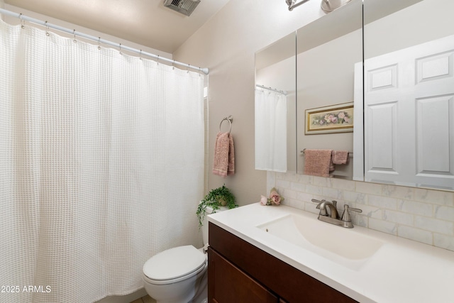 bathroom with vanity, backsplash, and toilet