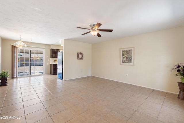 tiled empty room with ceiling fan with notable chandelier