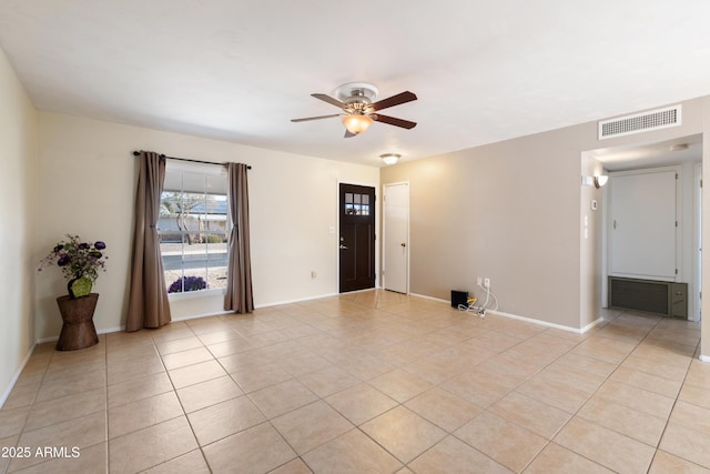 empty room with ceiling fan and light tile patterned floors