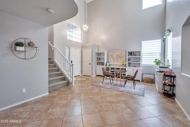 2210 W Goldmine Mountain Dr, Queen Creek, AZ 85144 - dining area with tile patterned floors, stairway, a towering ceiling, and baseboards