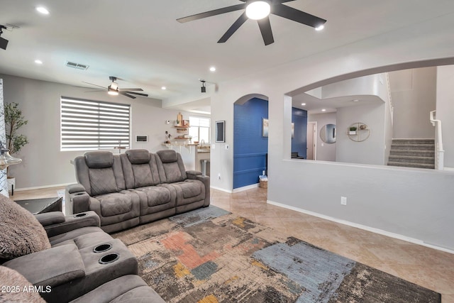 2210 W Goldmine Mountain Dr, Queen Creek, AZ 85144 - tiled living area with baseboards, stairway, visible vents, ceiling fan, and arched walkways