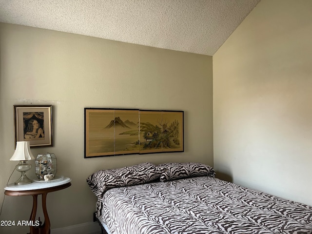 carpeted bedroom with a textured ceiling and lofted ceiling