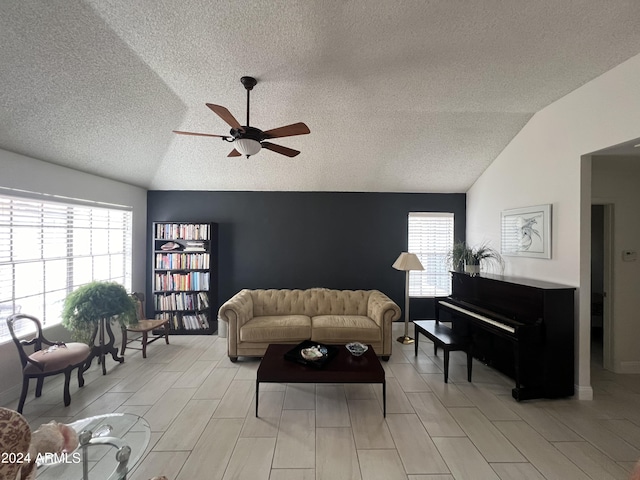 living room with a textured ceiling, vaulted ceiling, and ceiling fan