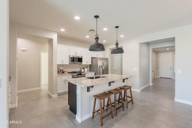 2680 E Daniel Dr, Gilbert, AZ 85298 - kitchen featuring appliances with stainless steel finishes, recessed lighting, a kitchen island with sink, white cabinetry, and a breakfast bar area