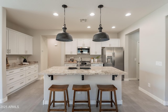 2680 E Daniel Dr, Gilbert, AZ 85298 - kitchen featuring appliances with stainless steel finishes, white cabinetry, a kitchen breakfast bar, light wood-type flooring, and recessed lighting