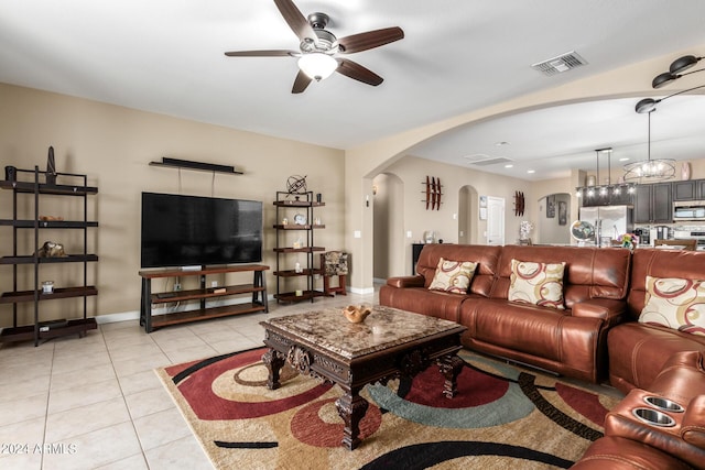 living room featuring ceiling fan with notable chandelier and light tile patterned floors