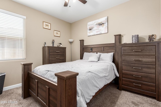 bedroom with ceiling fan, light carpet, and multiple windows