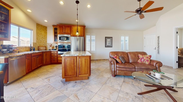 kitchen with backsplash, vaulted ceiling, appliances with stainless steel finishes, decorative light fixtures, and a kitchen island