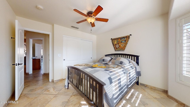 tiled bedroom with multiple windows, a closet, and ceiling fan