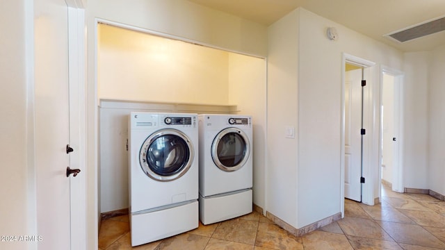 laundry room featuring light tile patterned floors and washer and dryer