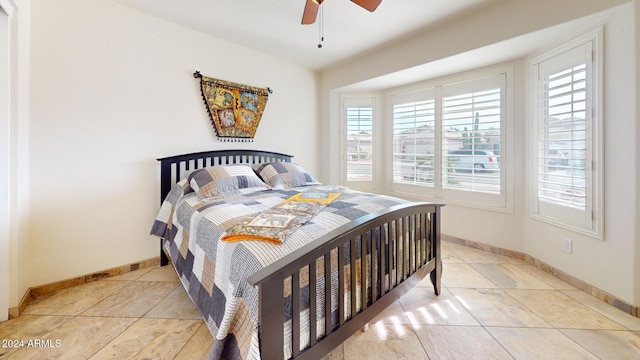 tiled bedroom featuring ceiling fan