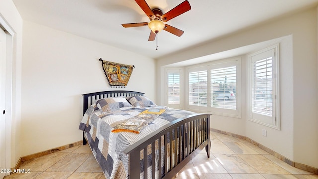 tiled bedroom featuring ceiling fan and a closet