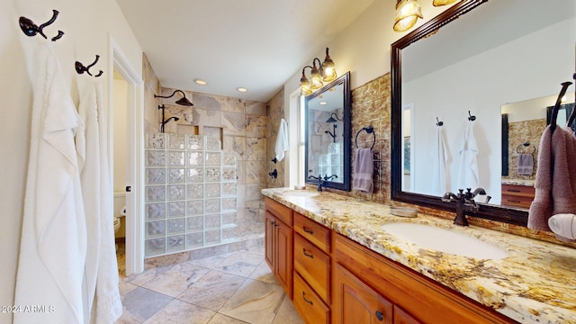 bathroom featuring vanity, toilet, and a tile shower