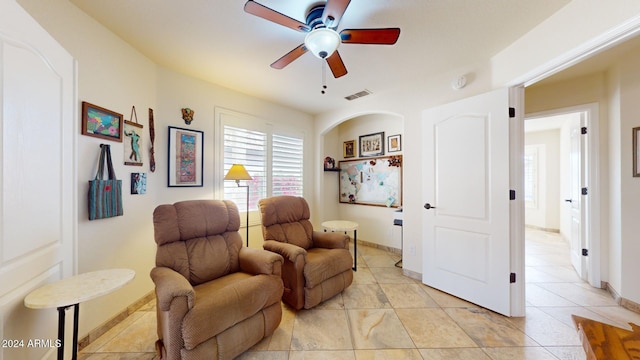 living area featuring light tile patterned floors and ceiling fan