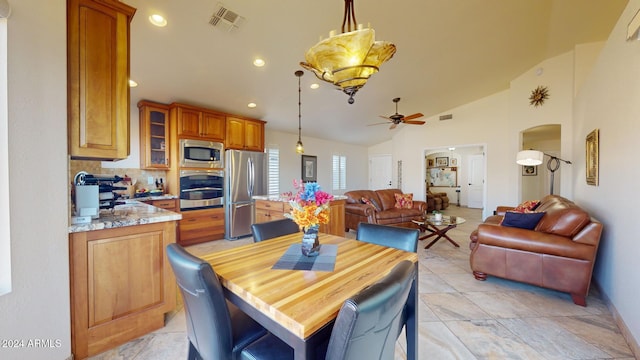 dining area with ceiling fan with notable chandelier and lofted ceiling