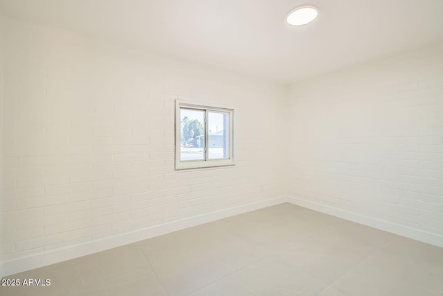 empty room featuring brick wall