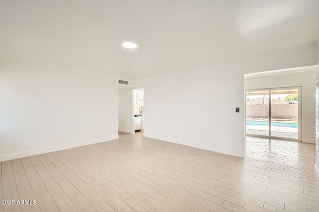 spare room with light wood-type flooring, visible vents, baseboards, and recessed lighting