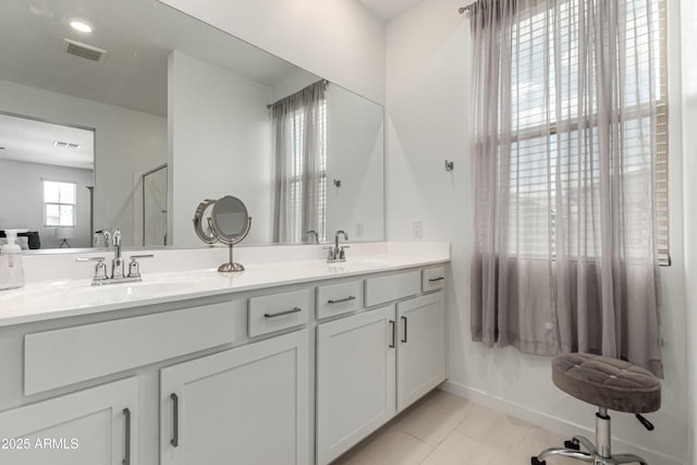 9901 E Tamery Ave, Mesa, AZ 85212 - full bathroom featuring double vanity, tile patterned flooring, baseboards, and an enclosed shower