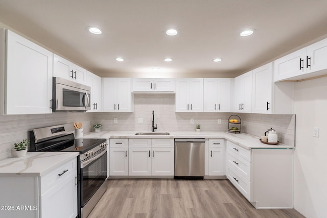 3620 E Ludlow Dr, Phoenix, AZ 85032 - kitchen with stainless steel appliances, a sink, light wood-style flooring, light stone counters, and recessed lighting