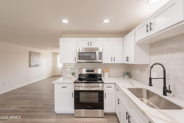 3620 E Ludlow Dr, Phoenix, AZ 85032 - kitchen featuring appliances with stainless steel finishes, a sink, white cabinets, tasteful backsplash, and recessed lighting